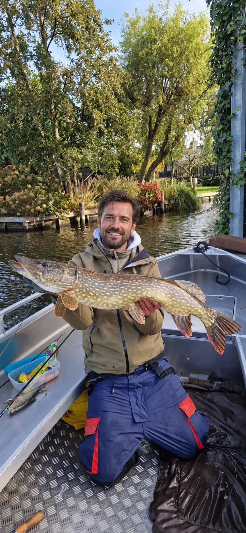 Visser toont een grote snoek vanuit een aluminium visboot op de Westeinderplassen